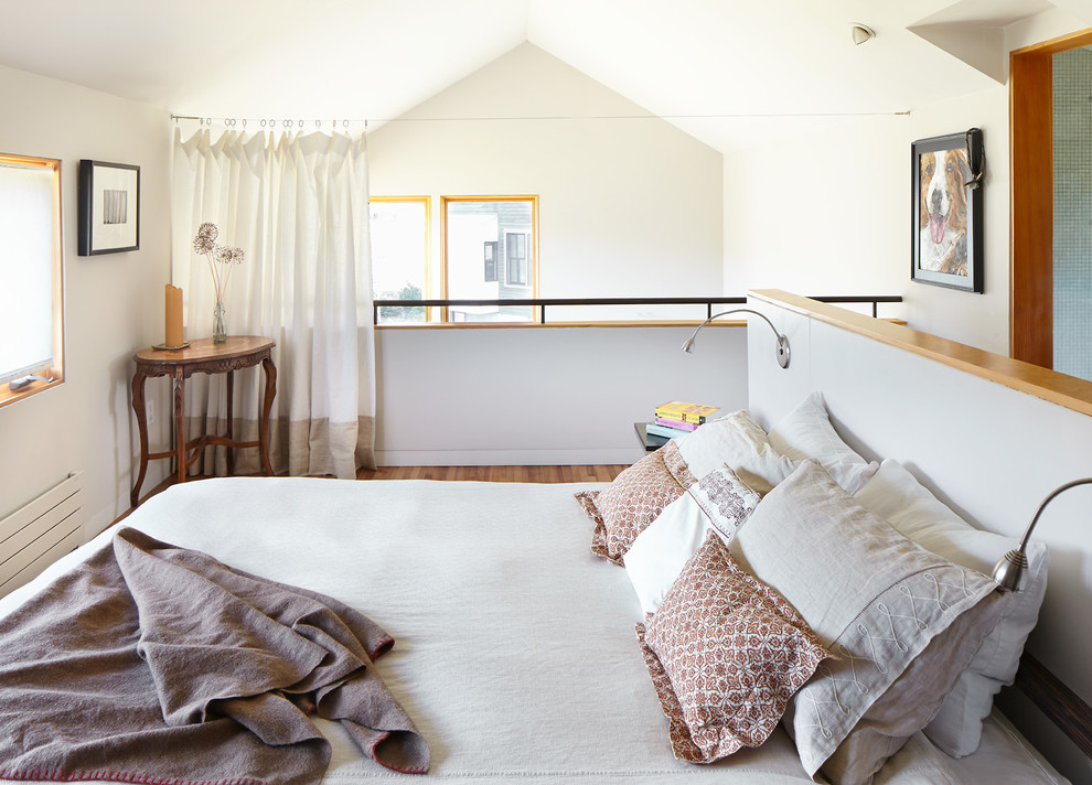 Esempio di una piccola e In mansarda camera da letto stile loft design con pareti grigie e parquet chiaro