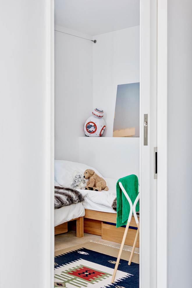 This is an example of an industrial guest bedroom in Boston with white walls.