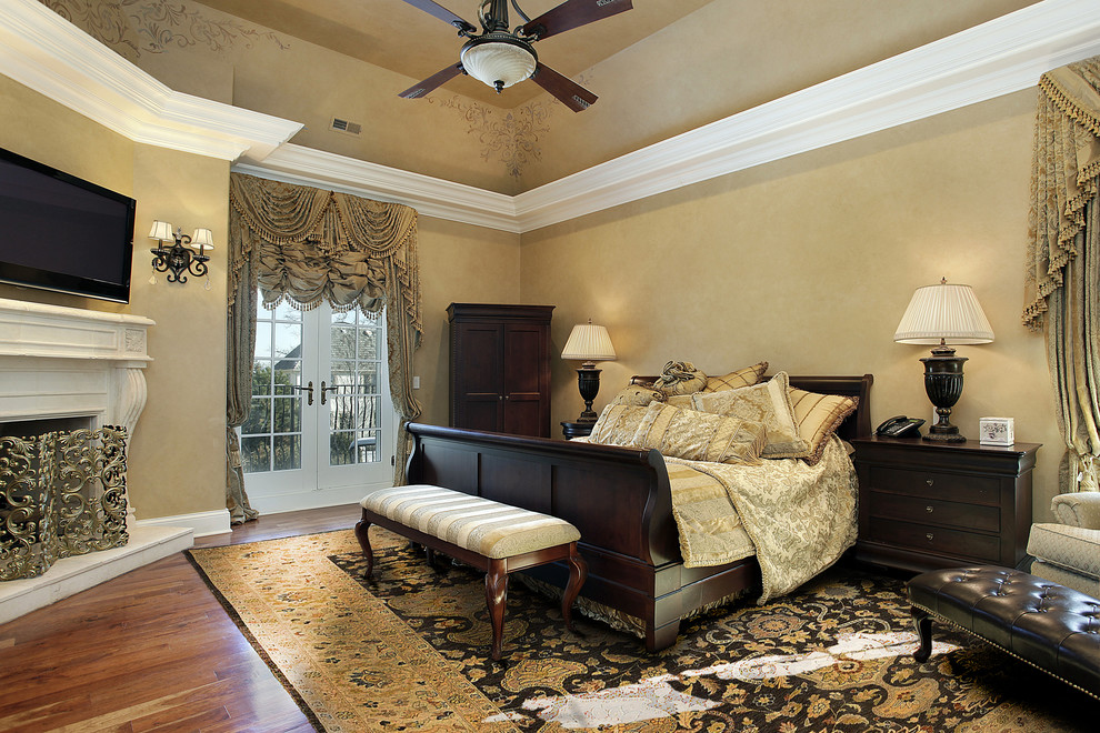 Großes Klassisches Hauptschlafzimmer mit brauner Wandfarbe, braunem Holzboden, Eckkamin, Kaminumrandung aus Stein und braunem Boden in Baltimore