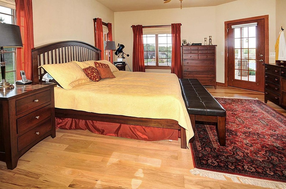 Idée de décoration pour une chambre parentale design de taille moyenne avec un mur beige, un sol en bois brun et aucune cheminée.