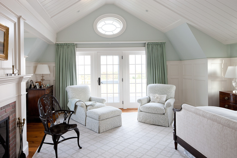 Aménagement d'une chambre d'amis classique de taille moyenne avec un mur bleu, un sol en bois brun, une cheminée standard et un manteau de cheminée en brique.