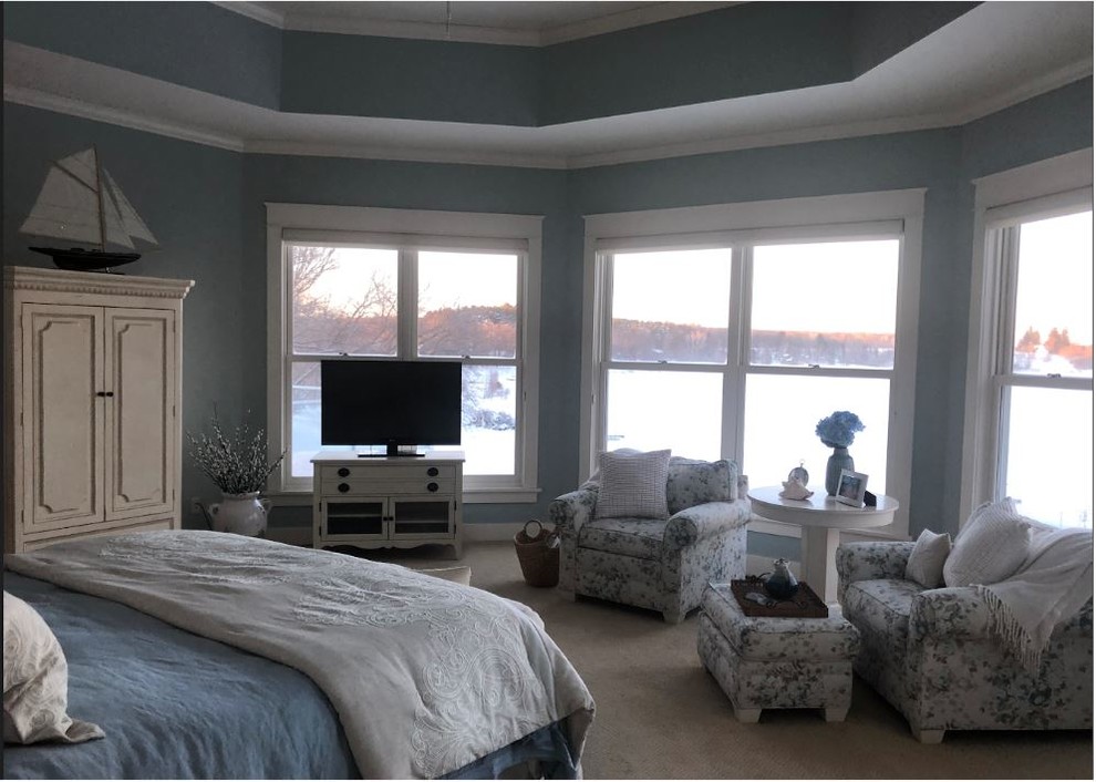 Réalisation d'une grande chambre tradition avec un mur bleu, une cheminée double-face, un manteau de cheminée en pierre et un sol beige.