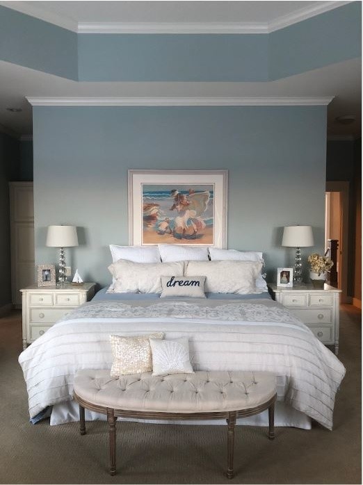 Idées déco pour une grande chambre classique avec un mur bleu, une cheminée double-face, un manteau de cheminée en pierre et un sol beige.