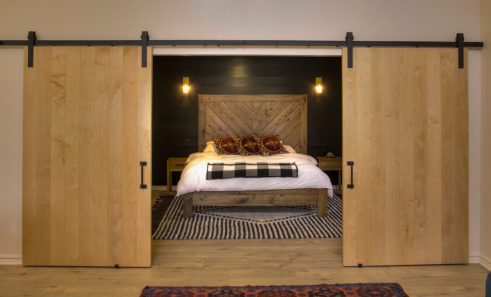 Mittelgroßes Modernes Hauptschlafzimmer mit schwarzer Wandfarbe und hellem Holzboden in Minneapolis