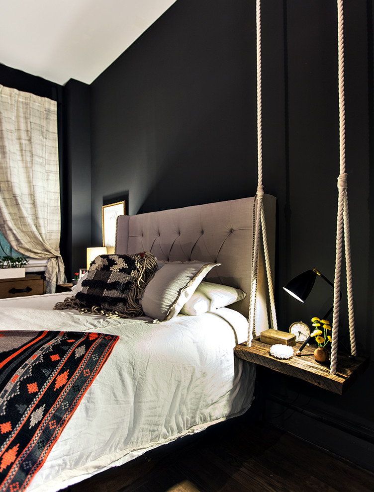 Immagine di una camera da letto rustica con pareti nere