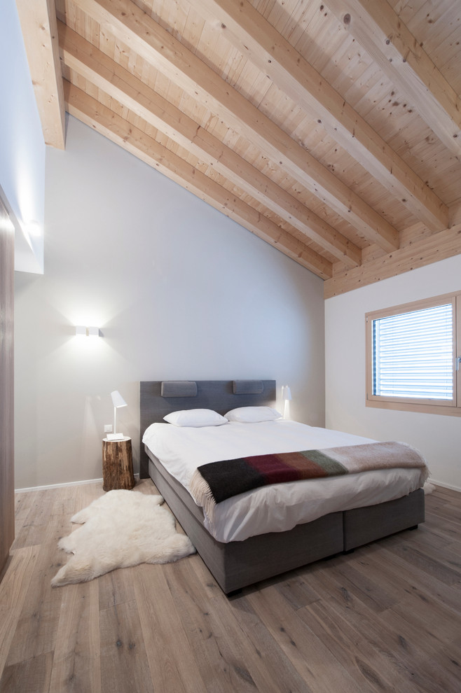 Imagen de dormitorio principal rústico grande con paredes beige y suelo de madera clara