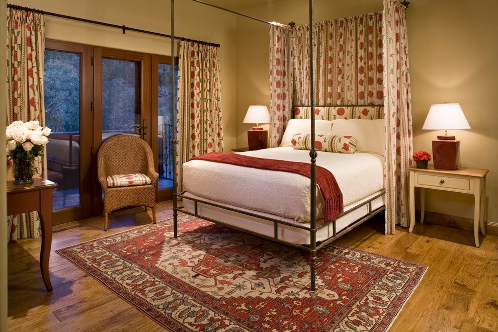 Modelo de dormitorio principal rural sin chimenea con paredes beige y suelo de madera en tonos medios