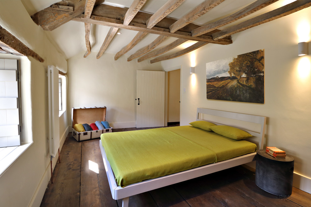 На фото: маленькая хозяйская спальня в стиле рустика с темным паркетным полом и белыми стенами для на участке и в саду с
