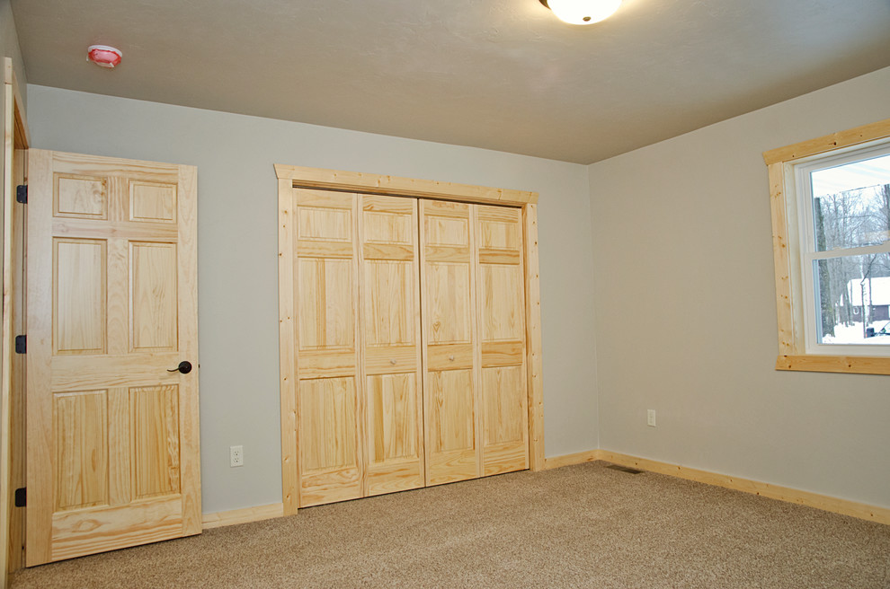 Photo of a medium sized rustic guest bedroom in Other with beige walls, carpet, no fireplace and brown floors.