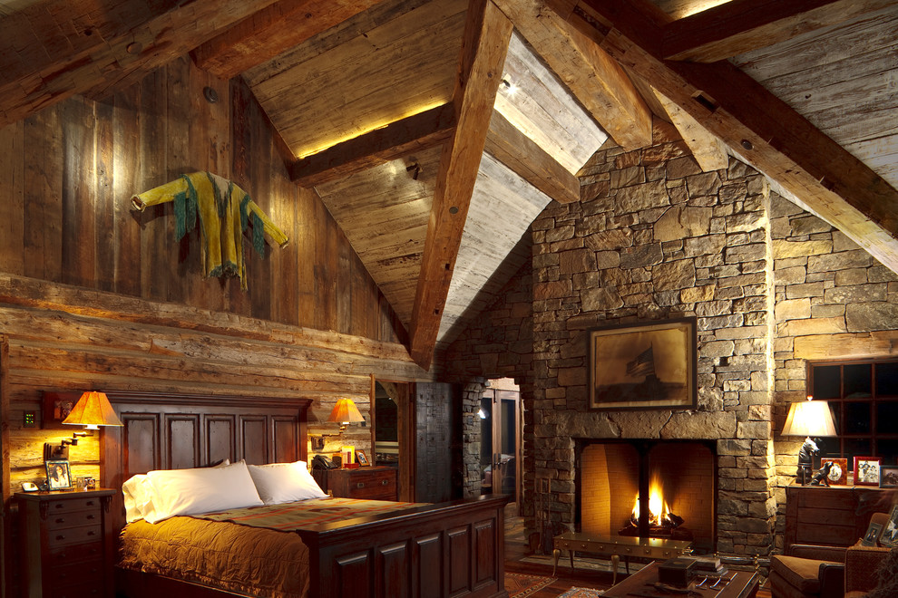 На фото: спальня в стиле рустика с стандартным камином и фасадом камина из камня с