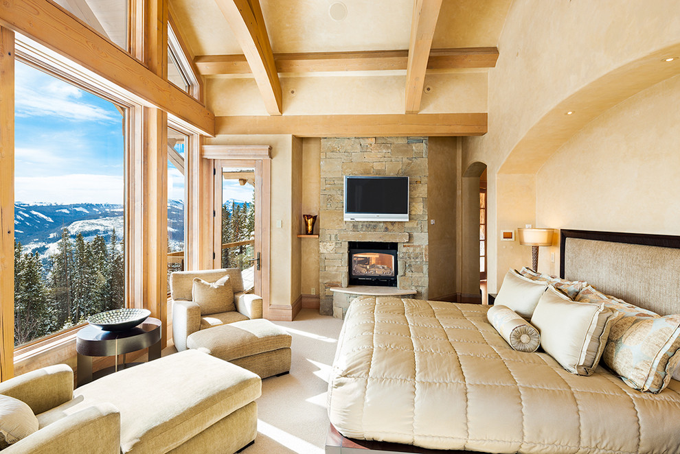 Mountain style bedroom photo in Other with a stone fireplace