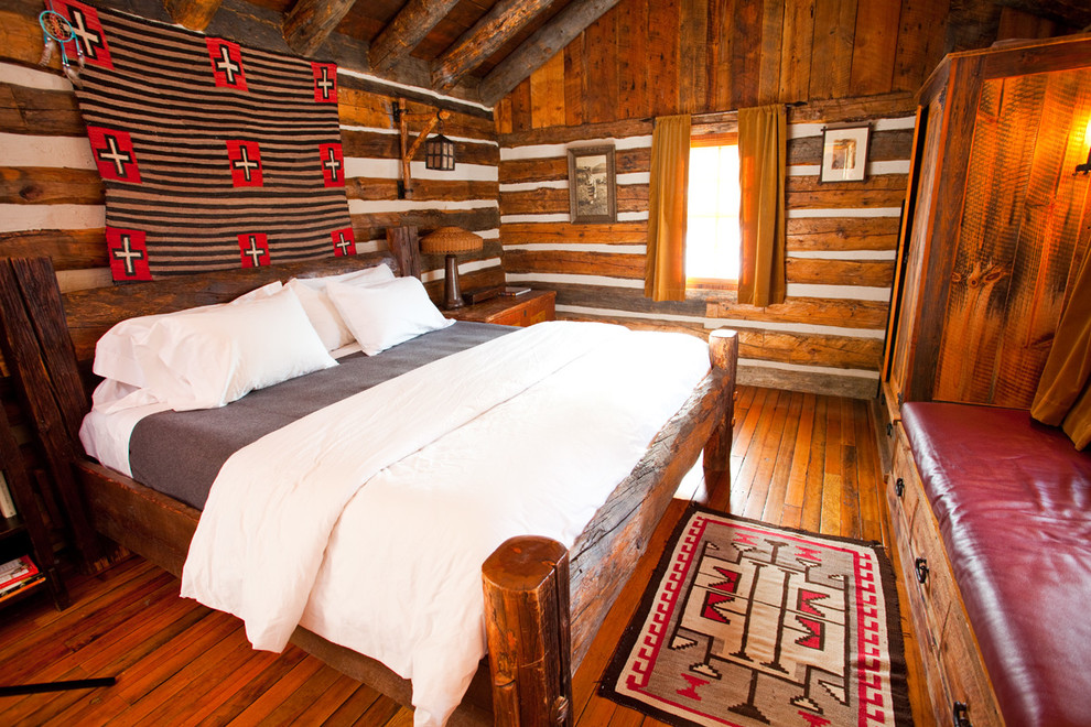 Idéer för att renovera ett rustikt sovrum, med mellanmörkt trägolv