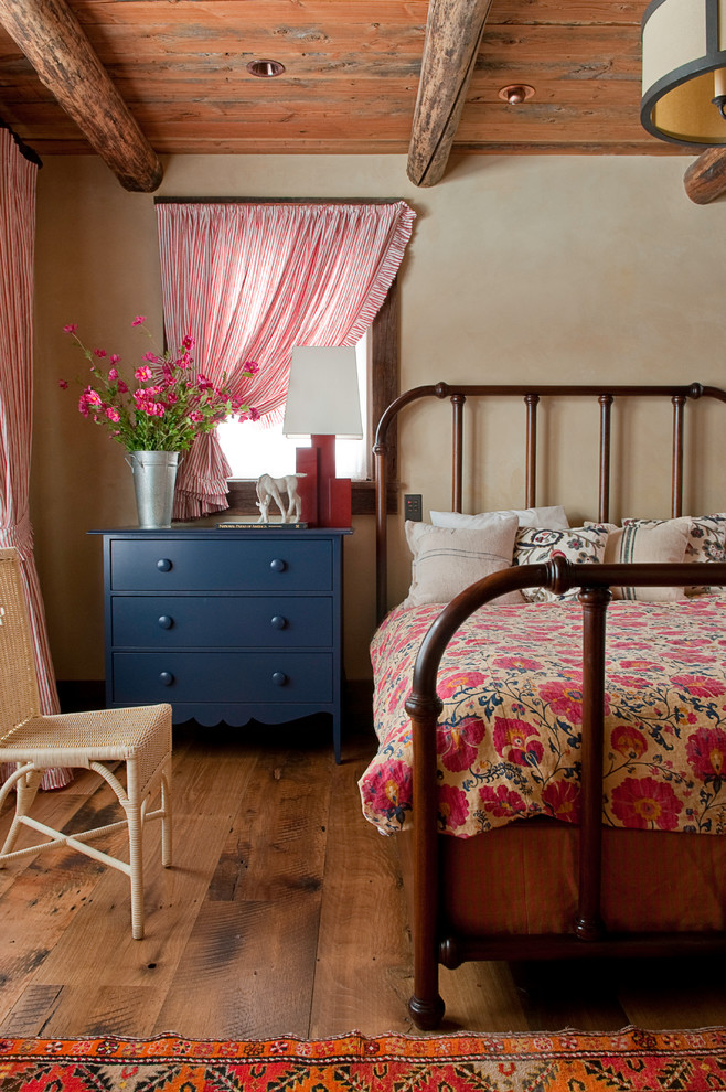 Bild på ett rustikt sovrum, med beige väggar och mörkt trägolv