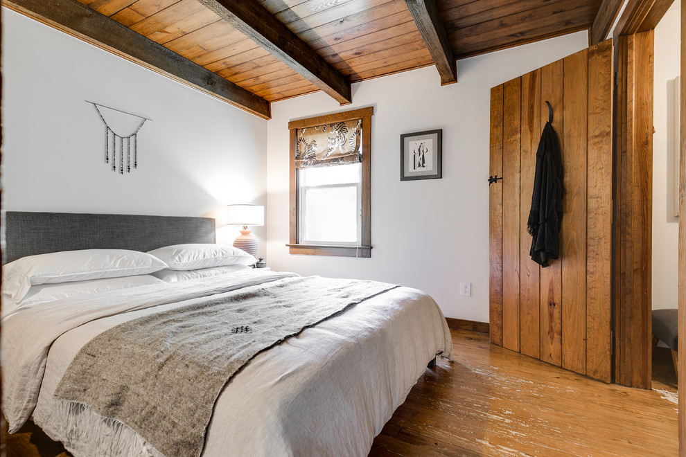 Стильный дизайн: спальня в стиле рустика с белыми стенами, паркетным полом среднего тона и коричневым полом - последний тренд