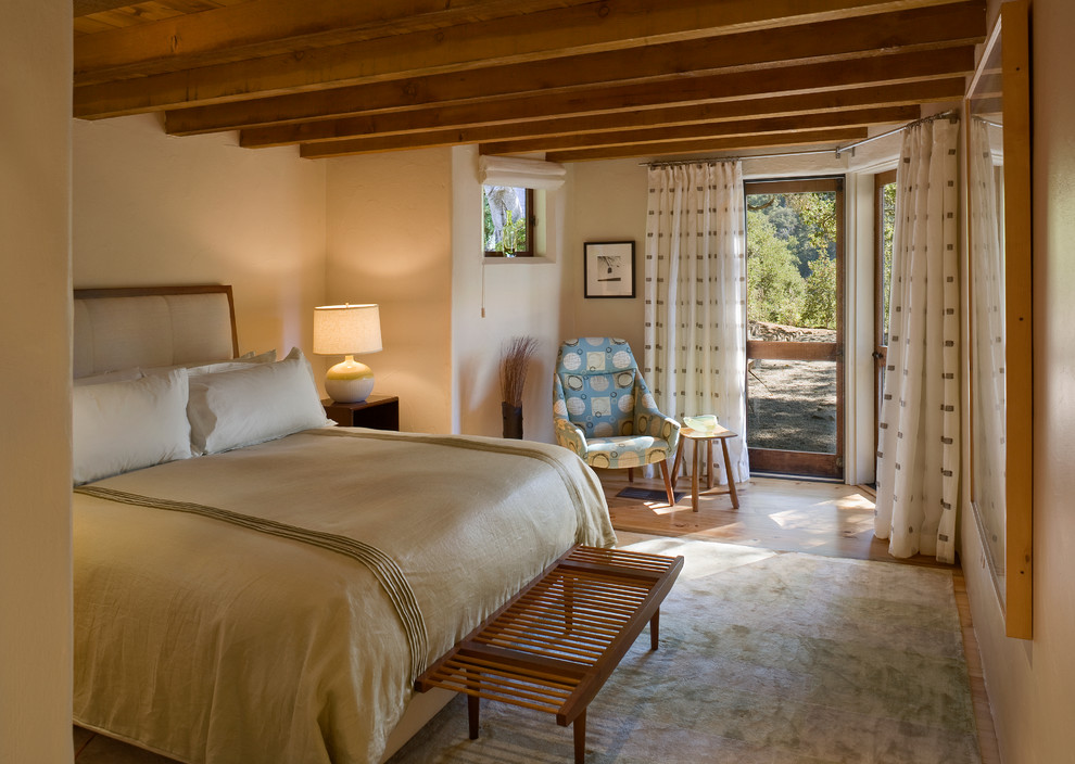 Ispirazione per una camera da letto rustica con pareti beige e pavimento in legno massello medio