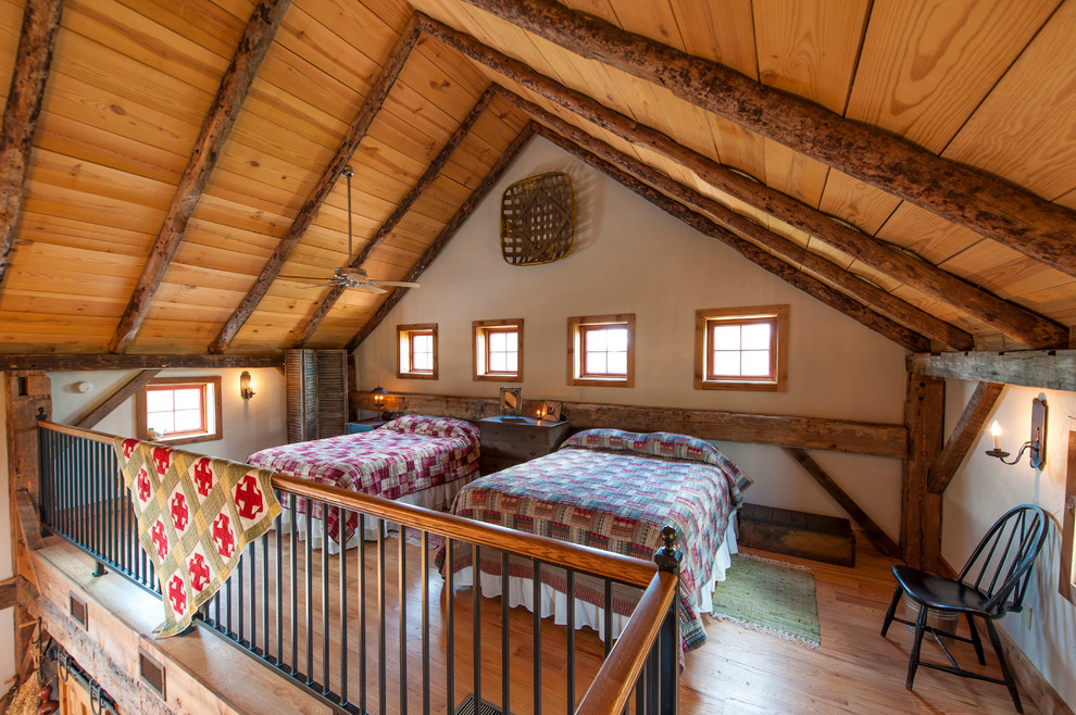 Uriges Schlafzimmer im Dachboden im Loft-Style mit weißer Wandfarbe und braunem Holzboden in Austin