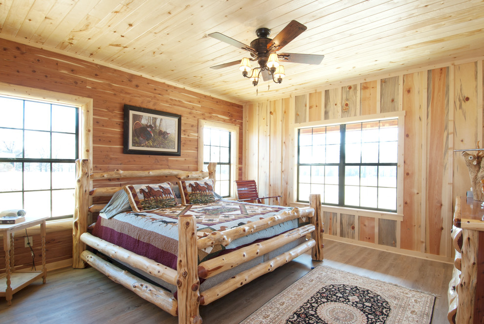 Modelo de dormitorio principal rústico de tamaño medio sin chimenea con suelo de madera clara