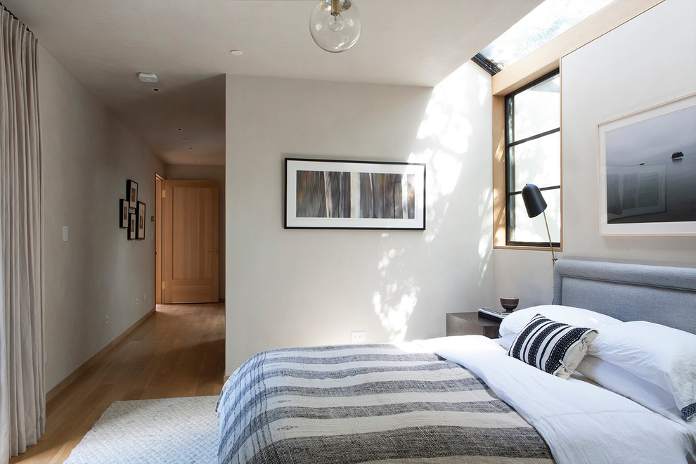 Exemple d'une chambre parentale moderne de taille moyenne avec un mur beige, parquet clair et aucune cheminée.