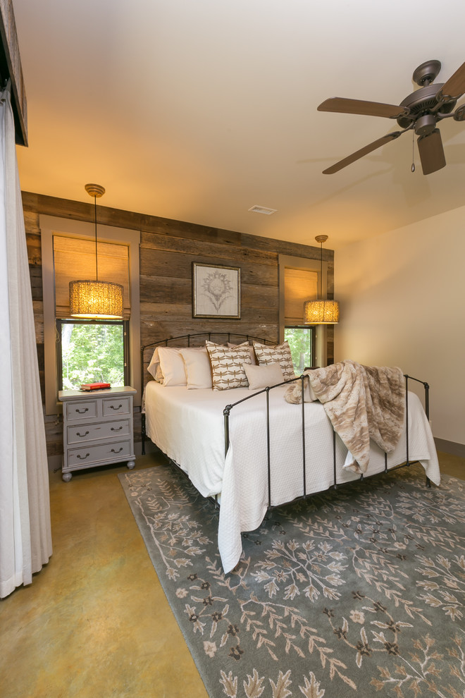 Photo of a rustic master bedroom in Charleston with beige walls and concrete flooring.