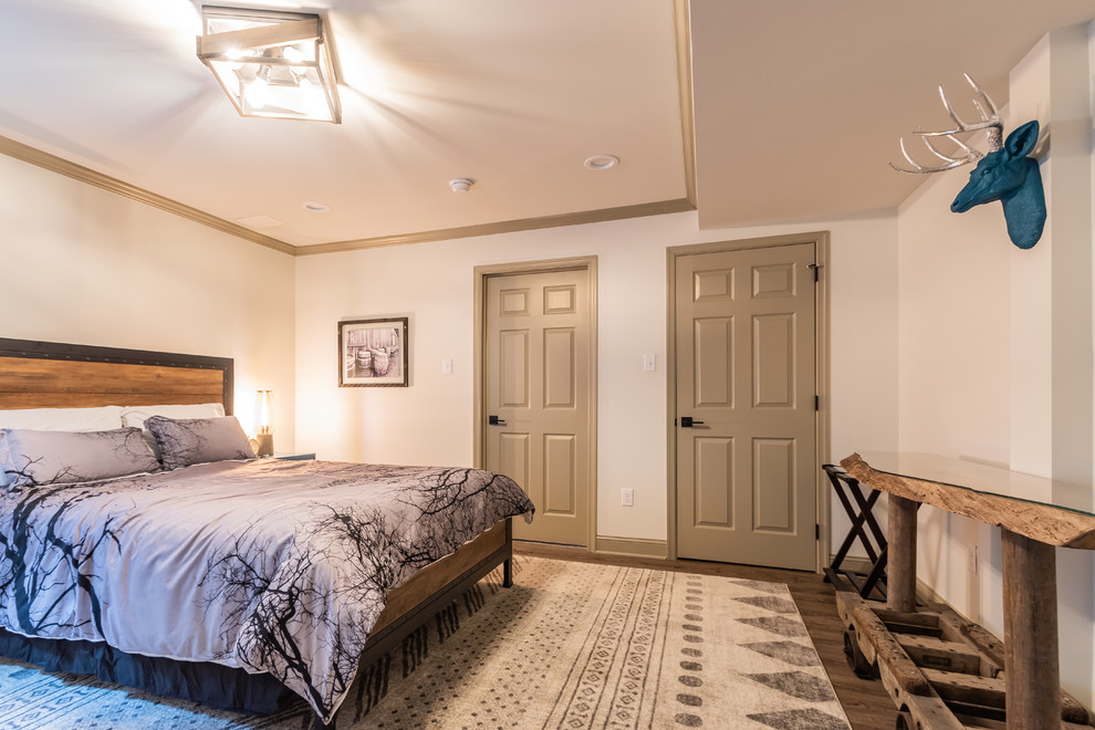 На фото: гостевая спальня среднего размера, (комната для гостей) в стиле рустика с белыми стенами, полом из ламината и коричневым полом