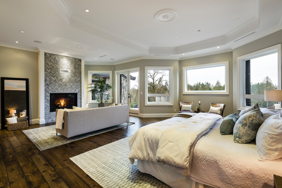 Свежая идея для дизайна: огромная хозяйская спальня в стиле рустика с серыми стенами, паркетным полом среднего тона, стандартным камином, фасадом камина из камня и коричневым полом - отличное фото интерьера