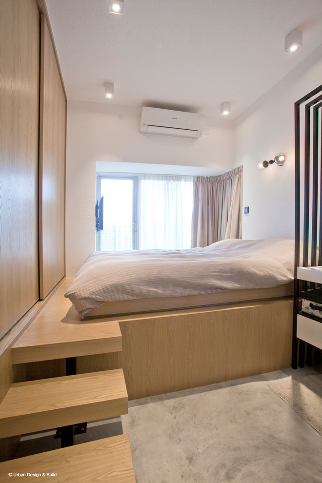 Industrial Hauptschlafzimmer mit weißer Wandfarbe und Betonboden in Hongkong