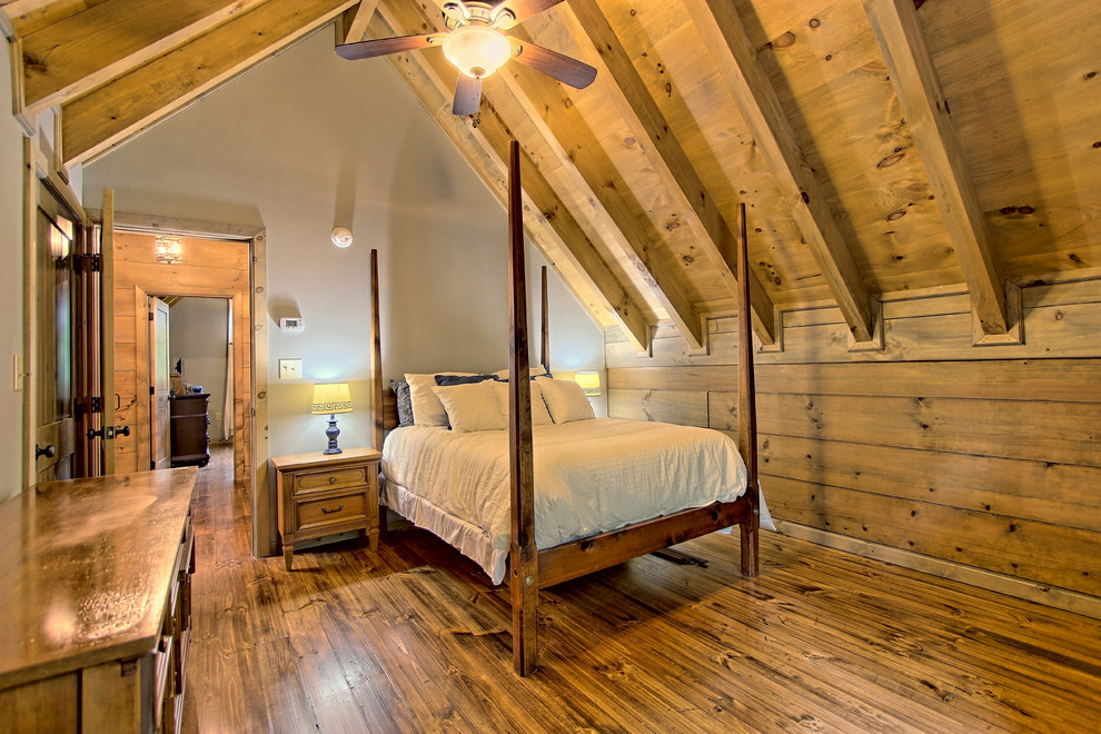 Immagine di una piccola camera degli ospiti rustica con pareti grigie, pavimento in legno verniciato e pavimento marrone
