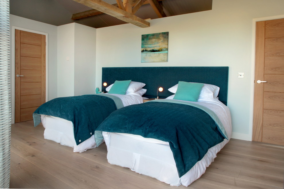 На фото: большая гостевая спальня (комната для гостей) в современном стиле с зелеными стенами и светлым паркетным полом
