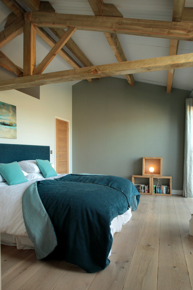 На фото: большая гостевая спальня (комната для гостей) в современном стиле с зелеными стенами и светлым паркетным полом с