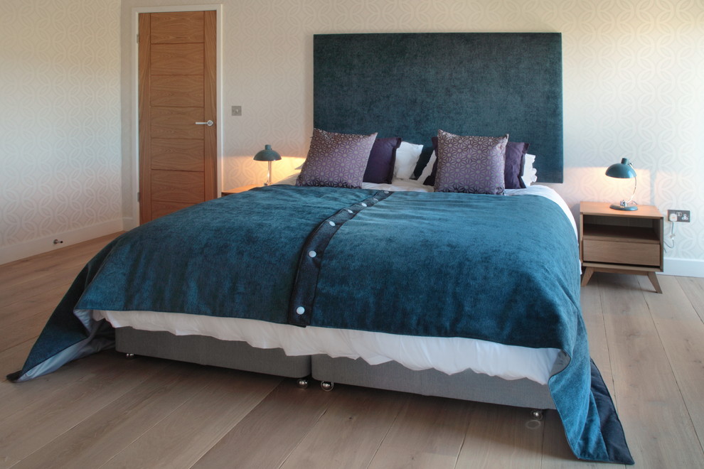 Photo of a large contemporary guest bedroom in Oxfordshire with light hardwood flooring and white walls.