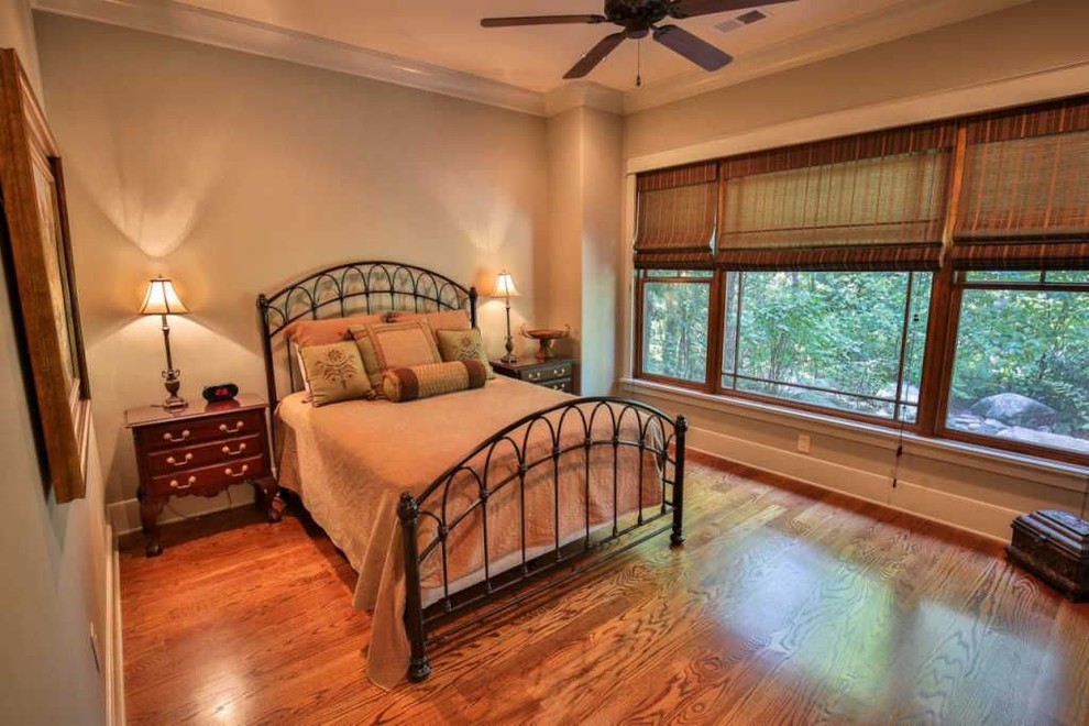 Ejemplo de habitación de invitados de estilo americano de tamaño medio sin chimenea con paredes beige, suelo de madera en tonos medios y suelo marrón