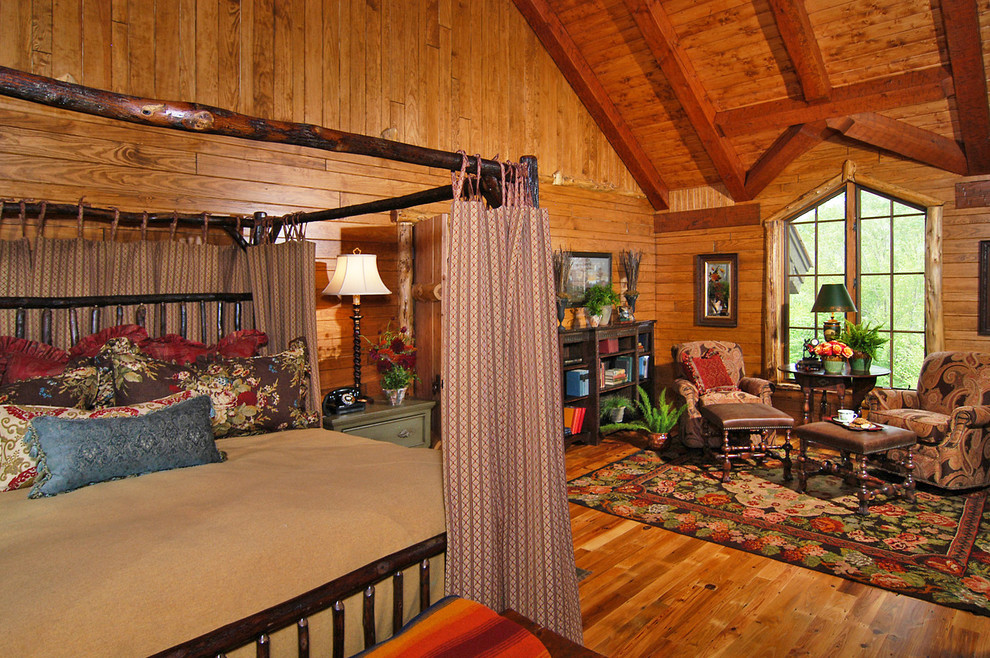 Large mountain style master medium tone wood floor bedroom photo in Charlotte with beige walls and no fireplace
