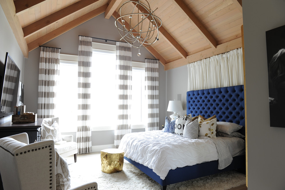 Diseño de dormitorio principal bohemio grande con paredes grises, suelo de madera clara y suelo marrón