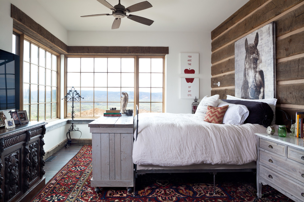 Großes Uriges Hauptschlafzimmer ohne Kamin mit weißer Wandfarbe und dunklem Holzboden in Denver