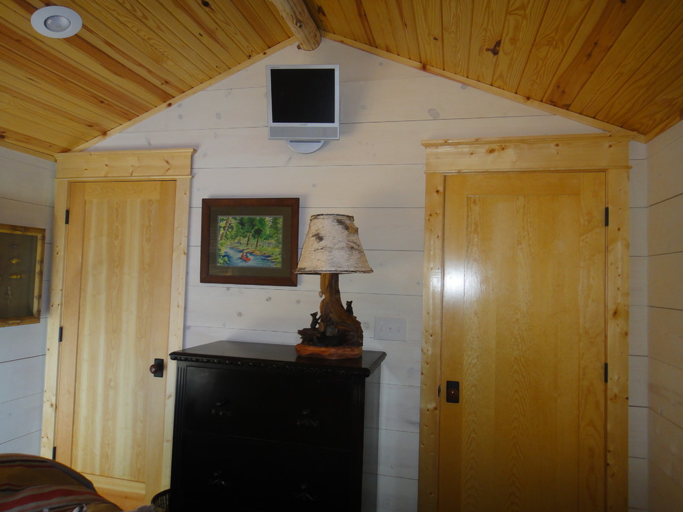 Imagen de habitación de invitados de estilo de casa de campo de tamaño medio con paredes blancas y suelo de madera en tonos medios