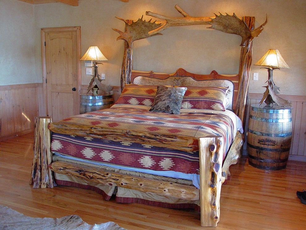 Immagine di una grande camera matrimoniale rustica con pareti beige e pavimento in legno massello medio