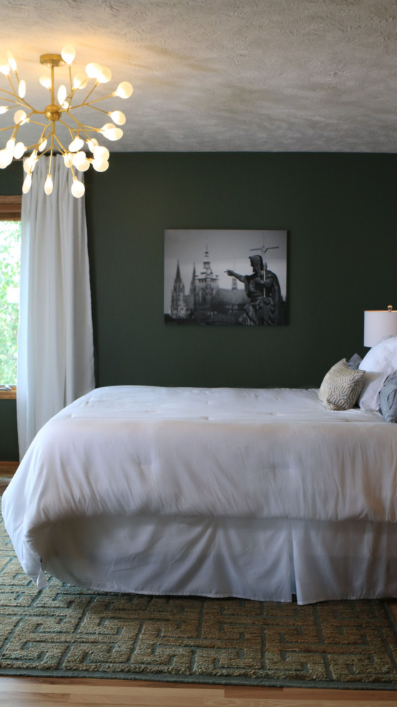 Inspiration pour une chambre parentale traditionnelle de taille moyenne avec un mur vert, un sol en bois brun et un sol marron.