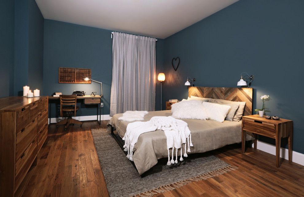 Example of a mid-sized mountain style master medium tone wood floor bedroom design in New York with blue walls