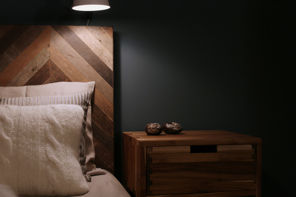 Idée de décoration pour une chambre parentale chalet de taille moyenne avec un mur bleu et un sol en bois brun.