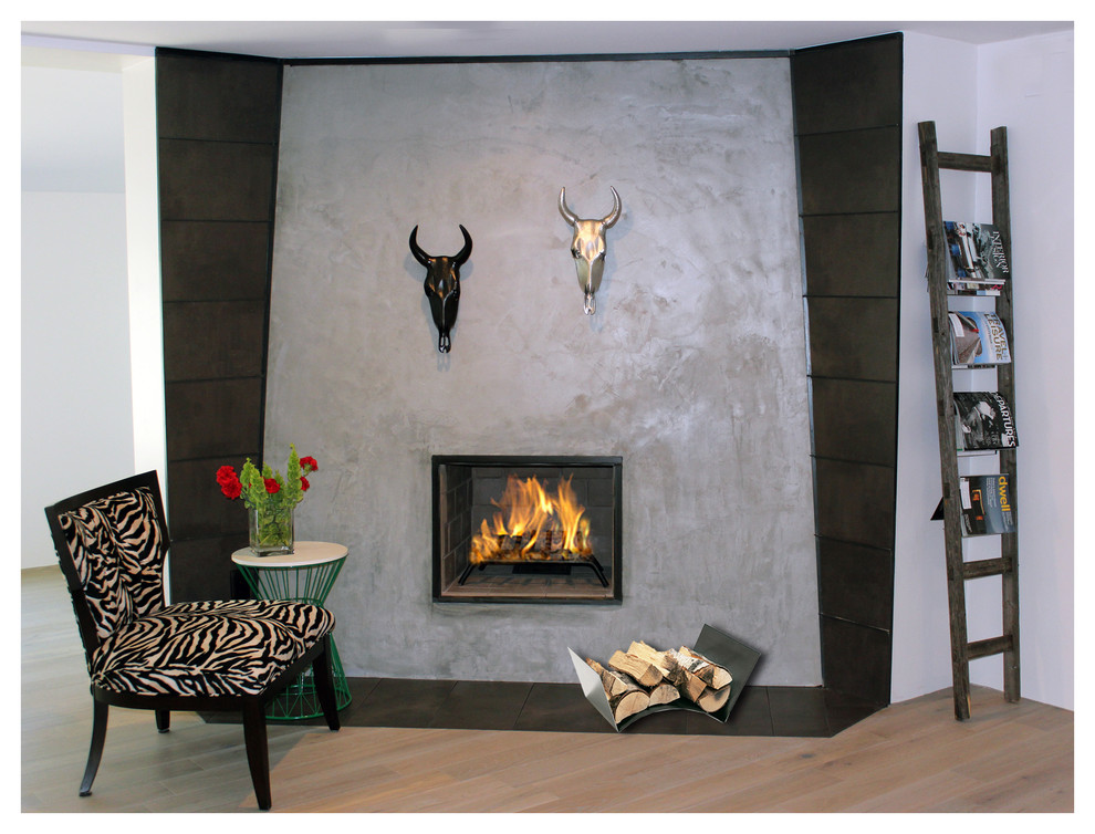 Cette image montre une petite chambre parentale minimaliste avec parquet clair, une cheminée d'angle et un manteau de cheminée en béton.