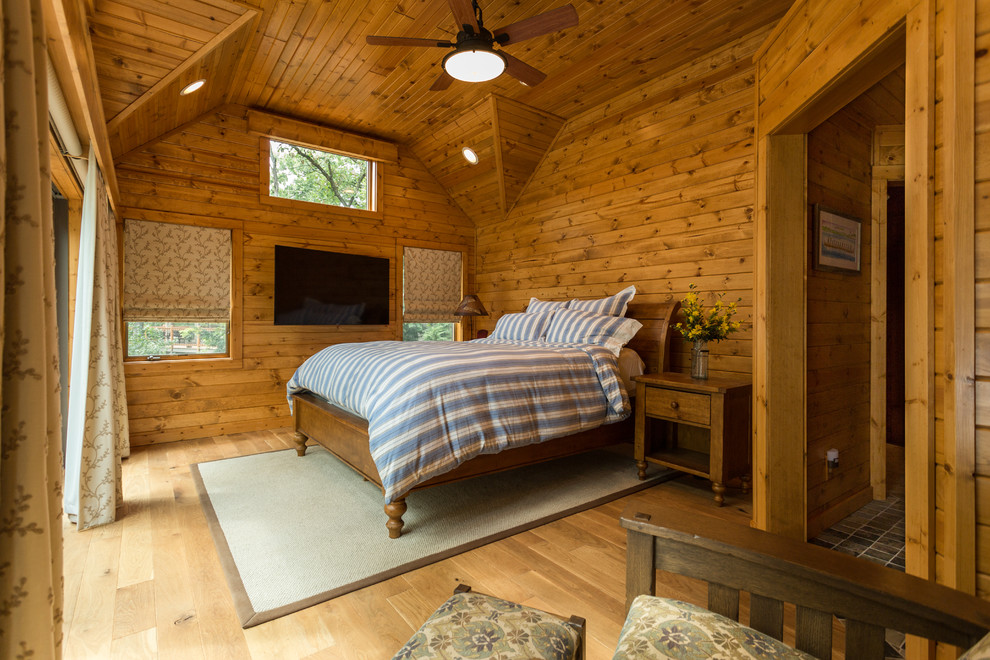 Modelo de dormitorio principal rural con suelo de madera clara