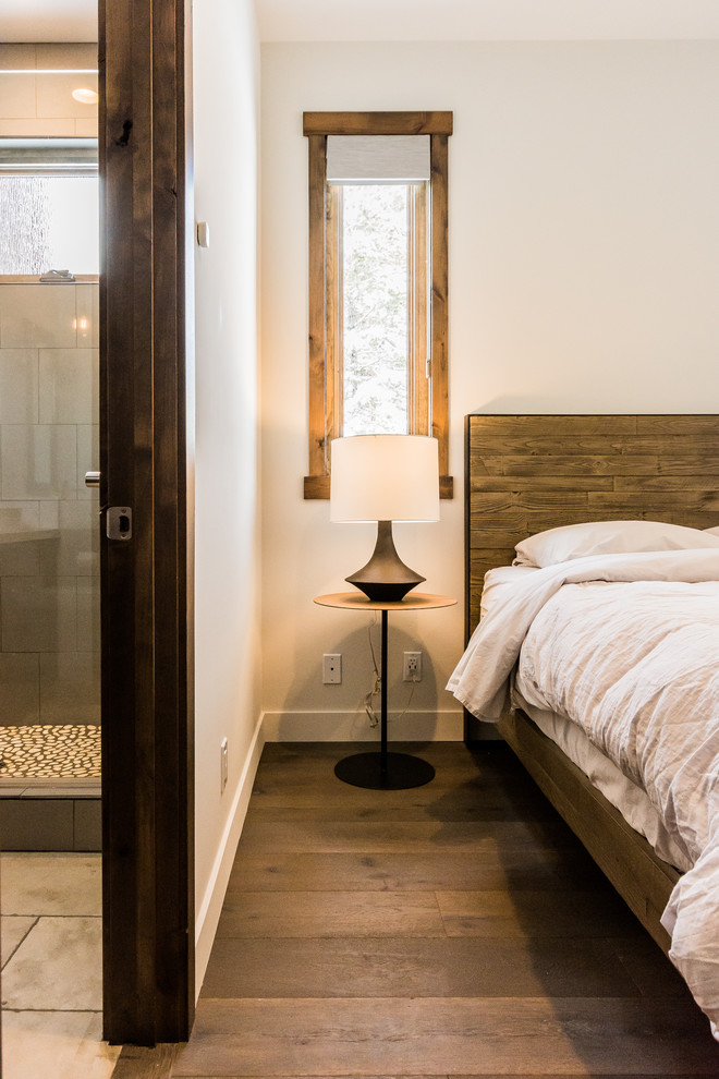 Imagen de habitación de invitados rústica de tamaño medio con paredes grises, suelo de madera en tonos medios y suelo gris