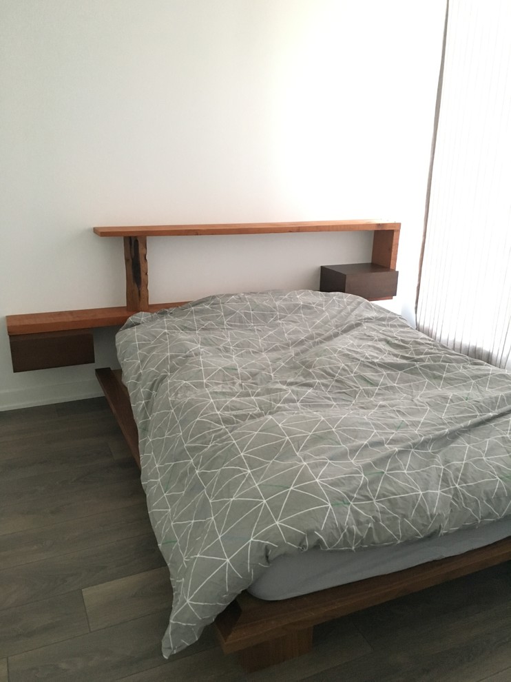 Kleines Uriges Hauptschlafzimmer ohne Kamin mit weißer Wandfarbe und dunklem Holzboden in Toronto