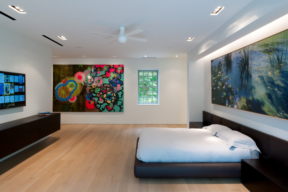 Ejemplo de dormitorio minimalista extra grande sin chimenea con paredes blancas, suelo de madera clara y suelo marrón