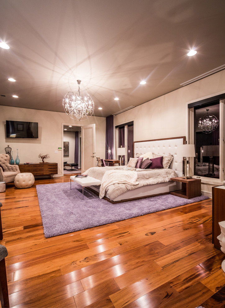Immagine di una camera matrimoniale minimalista con pavimento in legno massello medio e pareti bianche
