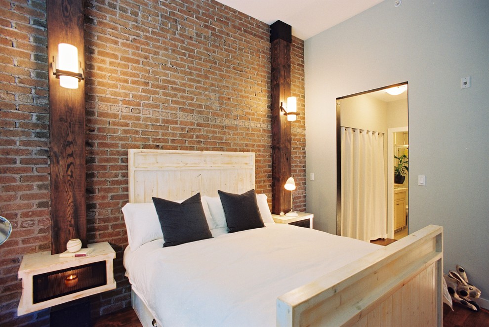 Diseño de dormitorio principal urbano de tamaño medio con suelo de madera en tonos medios, paredes multicolor y suelo marrón