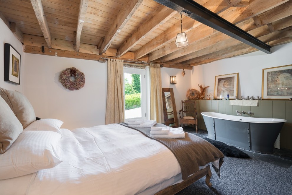 Mittelgroßes Landhaus Hauptschlafzimmer mit weißer Wandfarbe, Teppichboden und grauem Boden in Devon