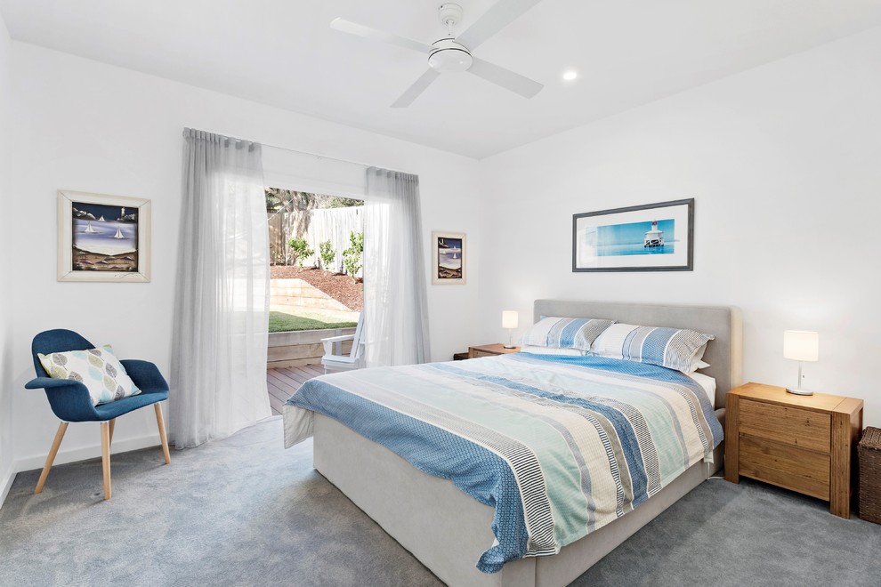 Immagine di una camera degli ospiti stile marino con pareti bianche, moquette e pavimento grigio