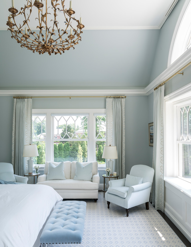 Large classic master bedroom in New York with blue walls, carpet and multi-coloured floors.