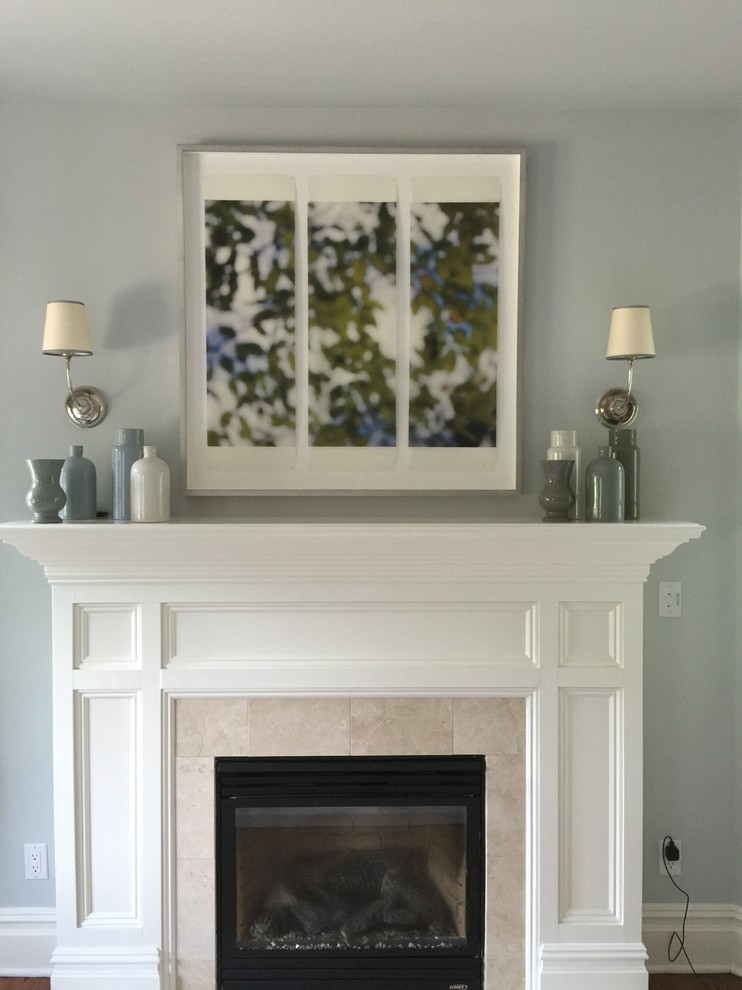 Inspiration pour un salon traditionnel de taille moyenne avec un mur bleu, un sol en bois brun, une cheminée standard et un manteau de cheminée en pierre.